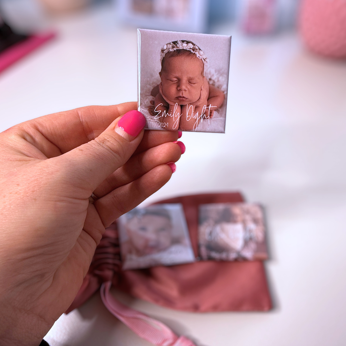 Hand holding personalised birth announcement photo magnet with sleeping newborn in floral headband — custom baby keepsake magnet handmade in Melbourne Australia