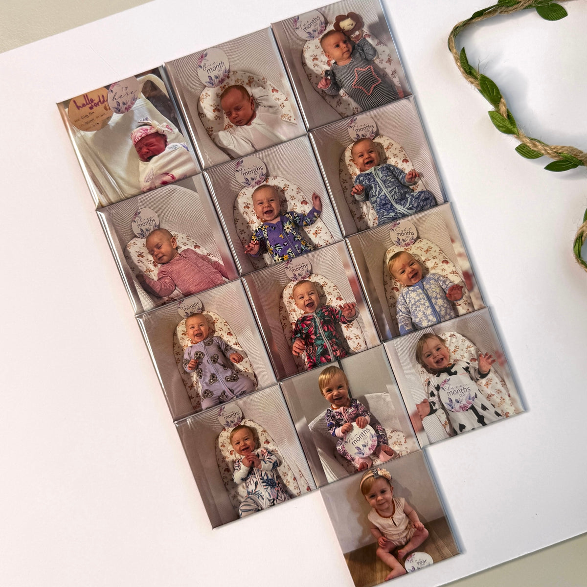 Flat lay of custom baby milestone magnets newborn to 12 months with eucalyptus wreath — personalised baby keepsake magnets handmade in Melbourne Australia