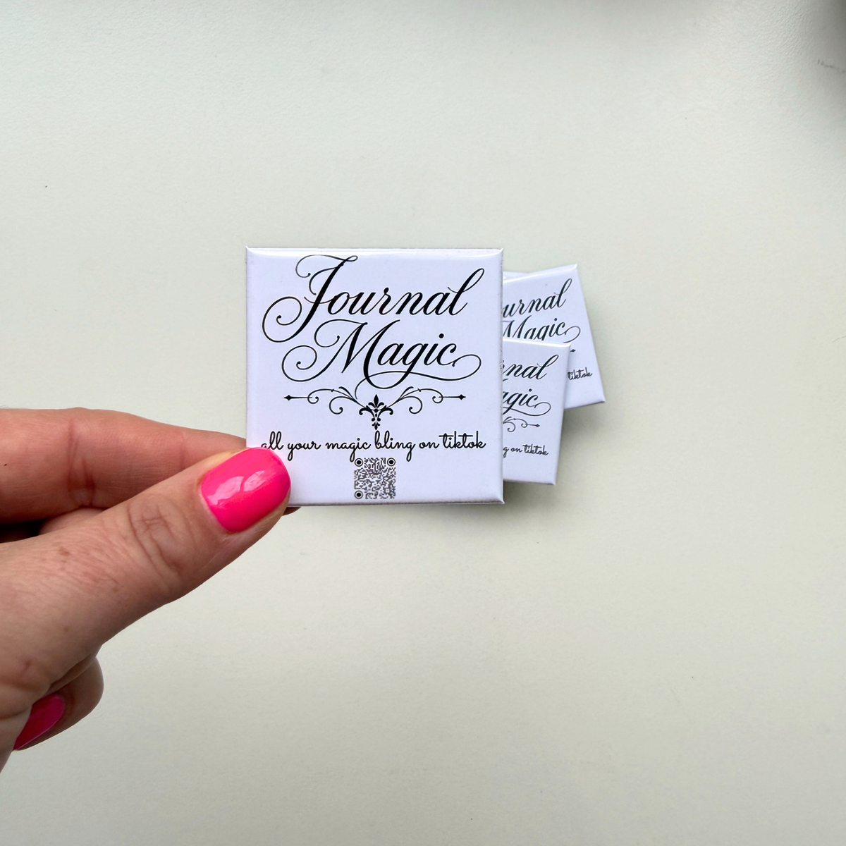  Hand holding custom branded magnet with Journal Magic logo — personalised event favour magnets handmade in Melbourne Australia