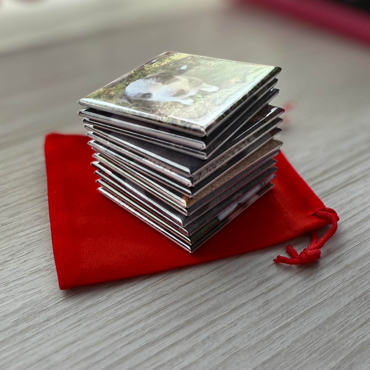 Stack of personalised pet photo magnets on red velvet pouch — custom cat and dog fridge magnets handmade in Melbourne Australia