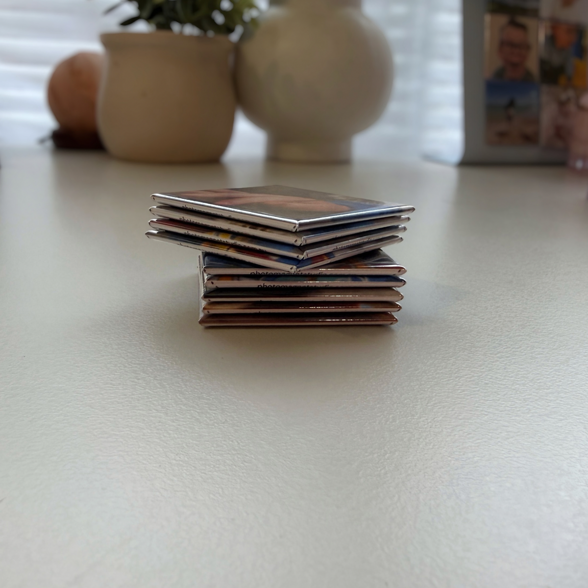  Side view of stacked 9-piece custom photo puzzle magnets on bench — personalised fridge magnets handmade in Melbourne Australia