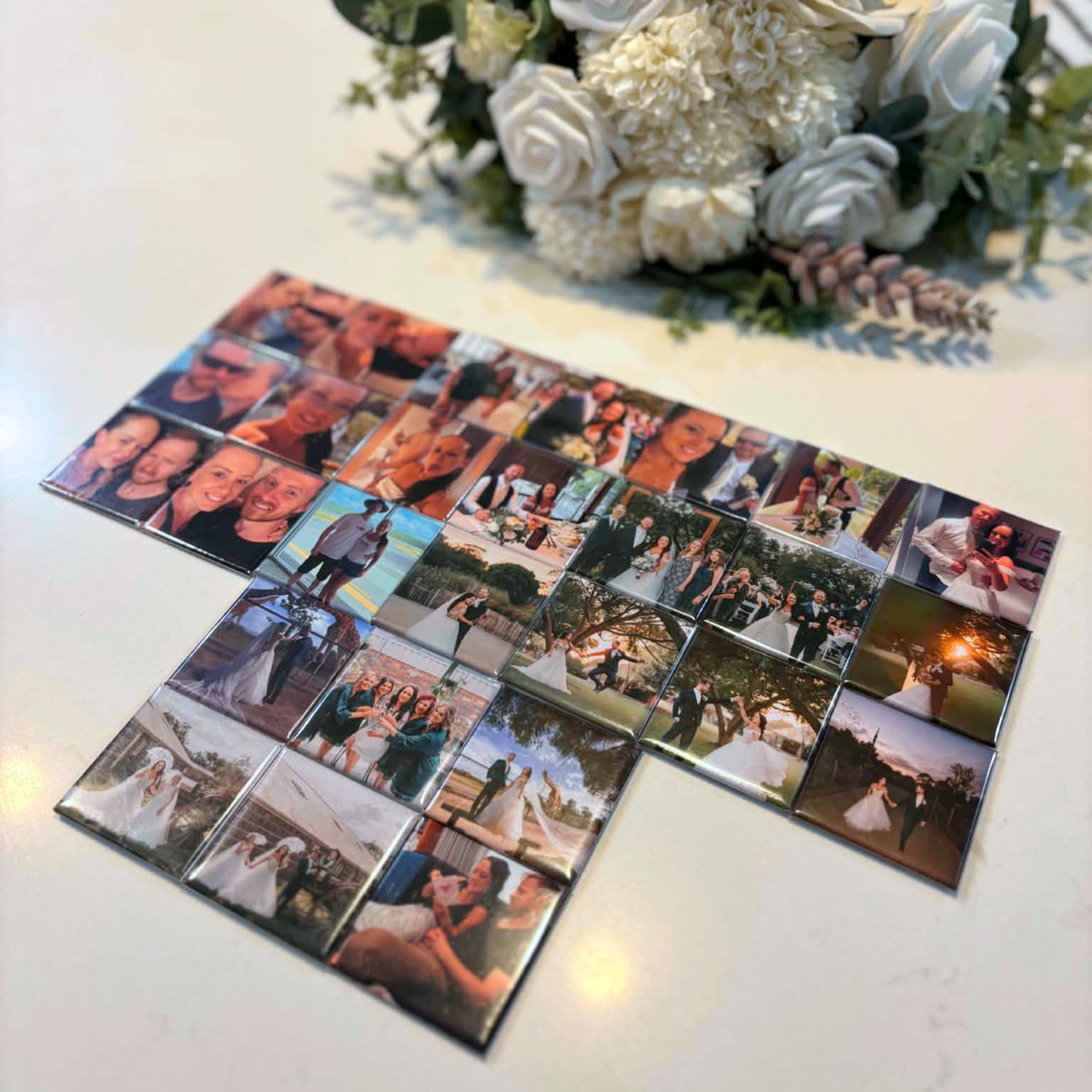 Flat lay of custom wedding photo magnets with white rose bouquet — personalised wedding keepsake magnets handmade in Melbourne Australia